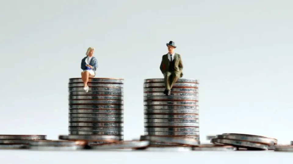 Bonecos de mulher e homem sentados em cima de moedas