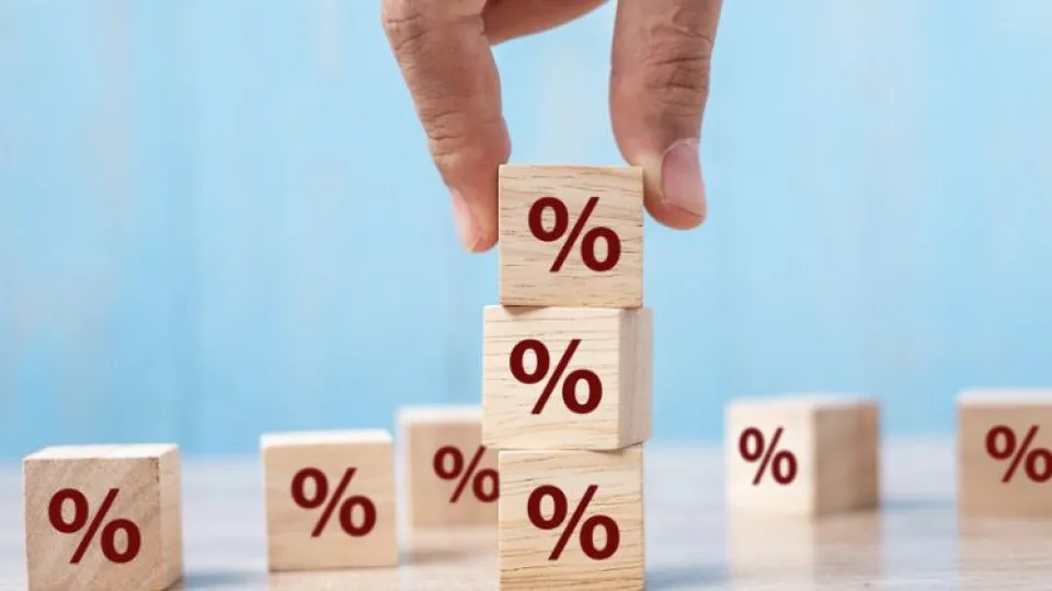 Cubos com percentagens de inflação e mão a fazer montes com os cubos