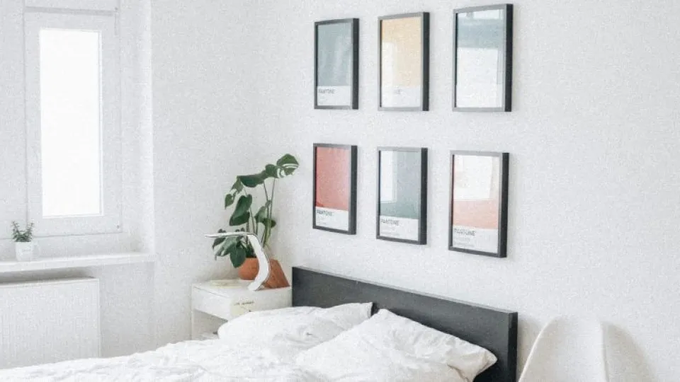 Quarto com cama e quadros pendurados na parede simbolizando habitação para jovens