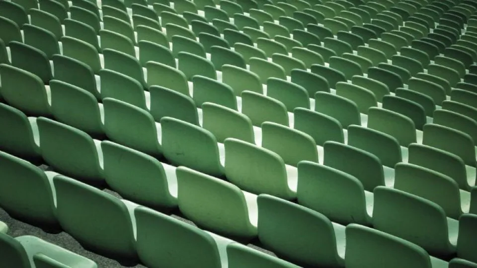 Cadeiras verdes em sala de espetáculo simbolizando revender bilhetes