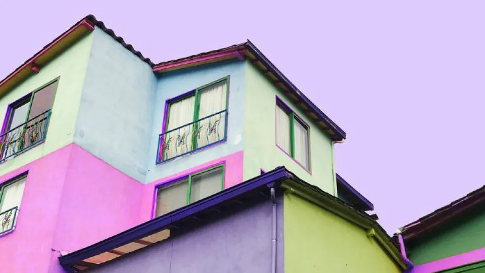 Mão a segurar casas de madeira com três montes a ir crescendo simbolizando arrendamento