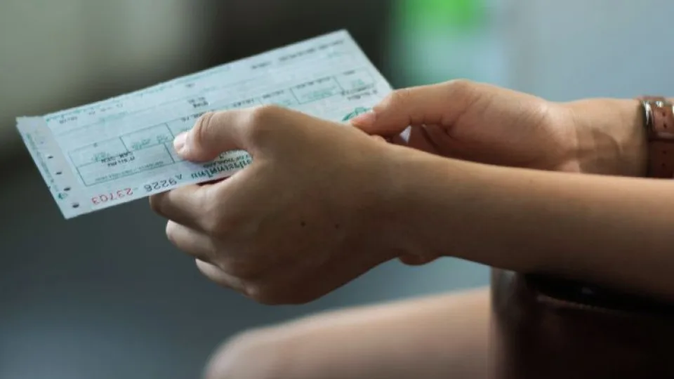 Mãos de mulher a segurar bilhete simbolizando revenda