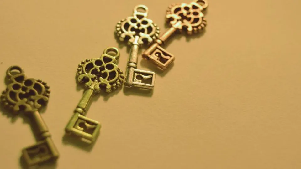 Chaves douradas sob fundo laranja simbolizando habitação