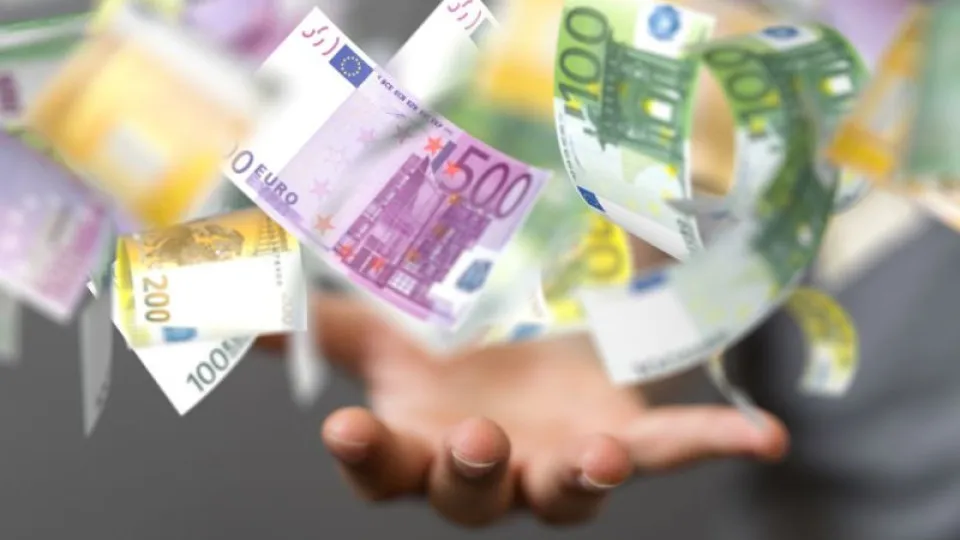 Notas de euro a flutuar sobre uma mão estendida, simbolizando dinheiro a chegar.