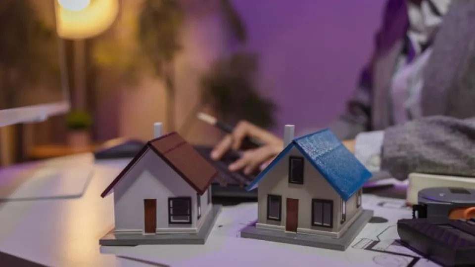 Maquetes de casas sobre uma mesa, representando o processo de contratação de crédito habitação