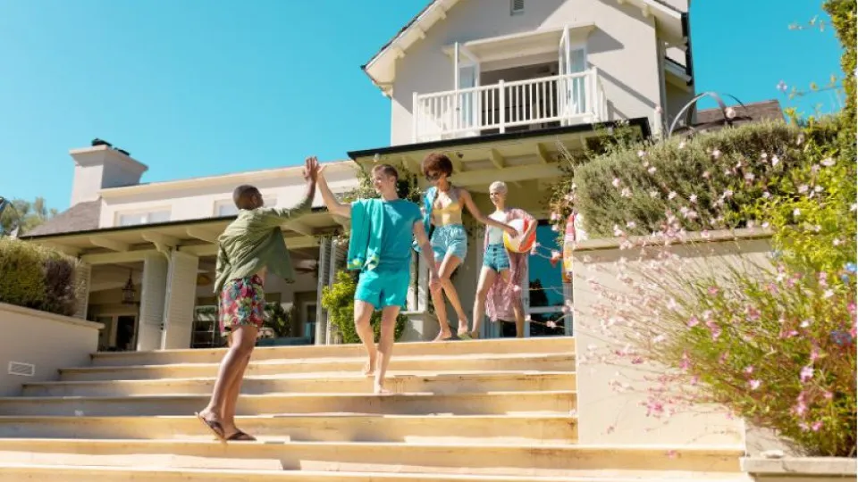 Grupo de jovens a descer escadas de casa de férias