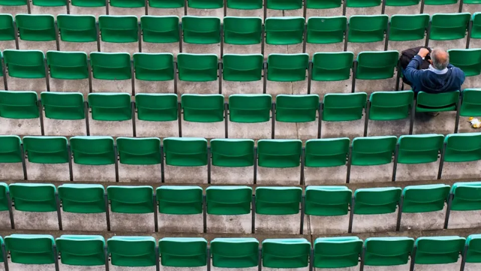 Senhor sozinho sentado numa arquibancada - conceito de solidão