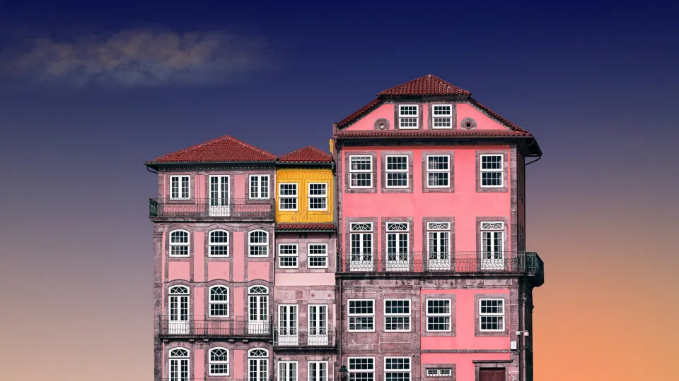 Prédios coloridos antigos típicos de Portugal com céu ao entardecer ao fundo.