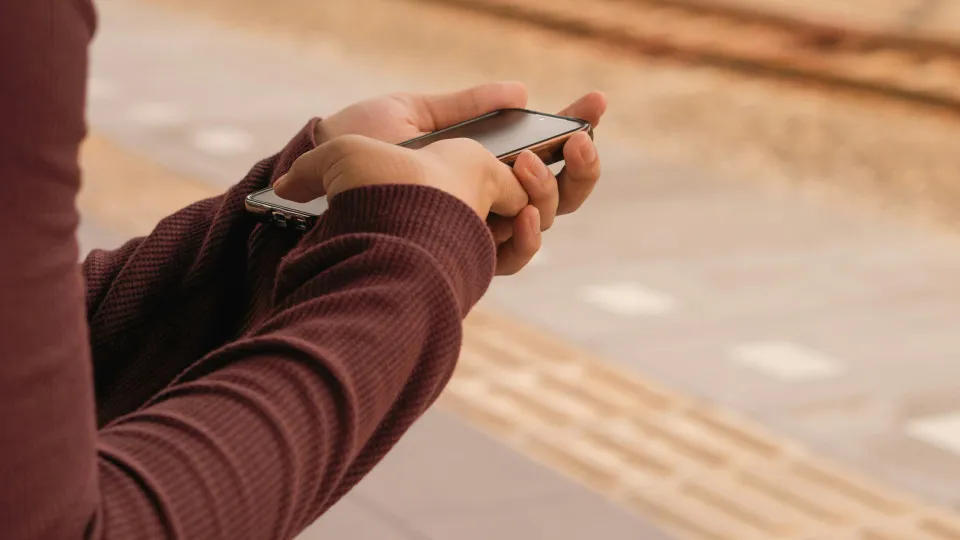 Pessoa a usar smartphone - conceito de gestão de finanças pessoais via app.