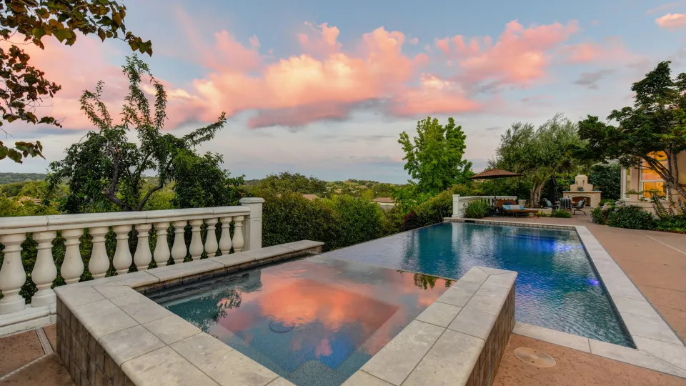 Casa moderna com piscina de borda infinita, evocando a ideia de uma casa de férias, ideal para ilustrar o conceito de segundo crédito habitação para comprar uma nova propriedade.