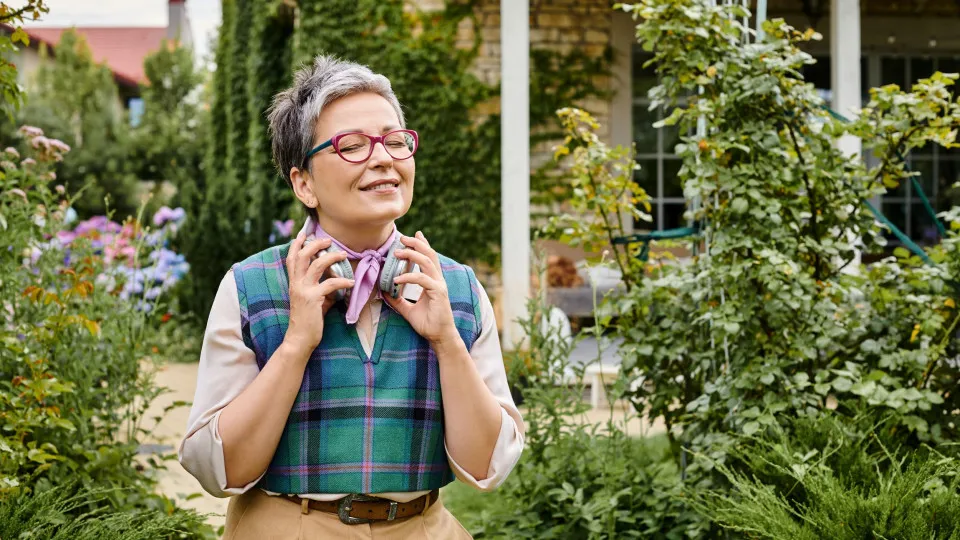 Mulher a sorrir num jardim, simbolizando tranquilidade e segurança associadas ao seguro de vida.